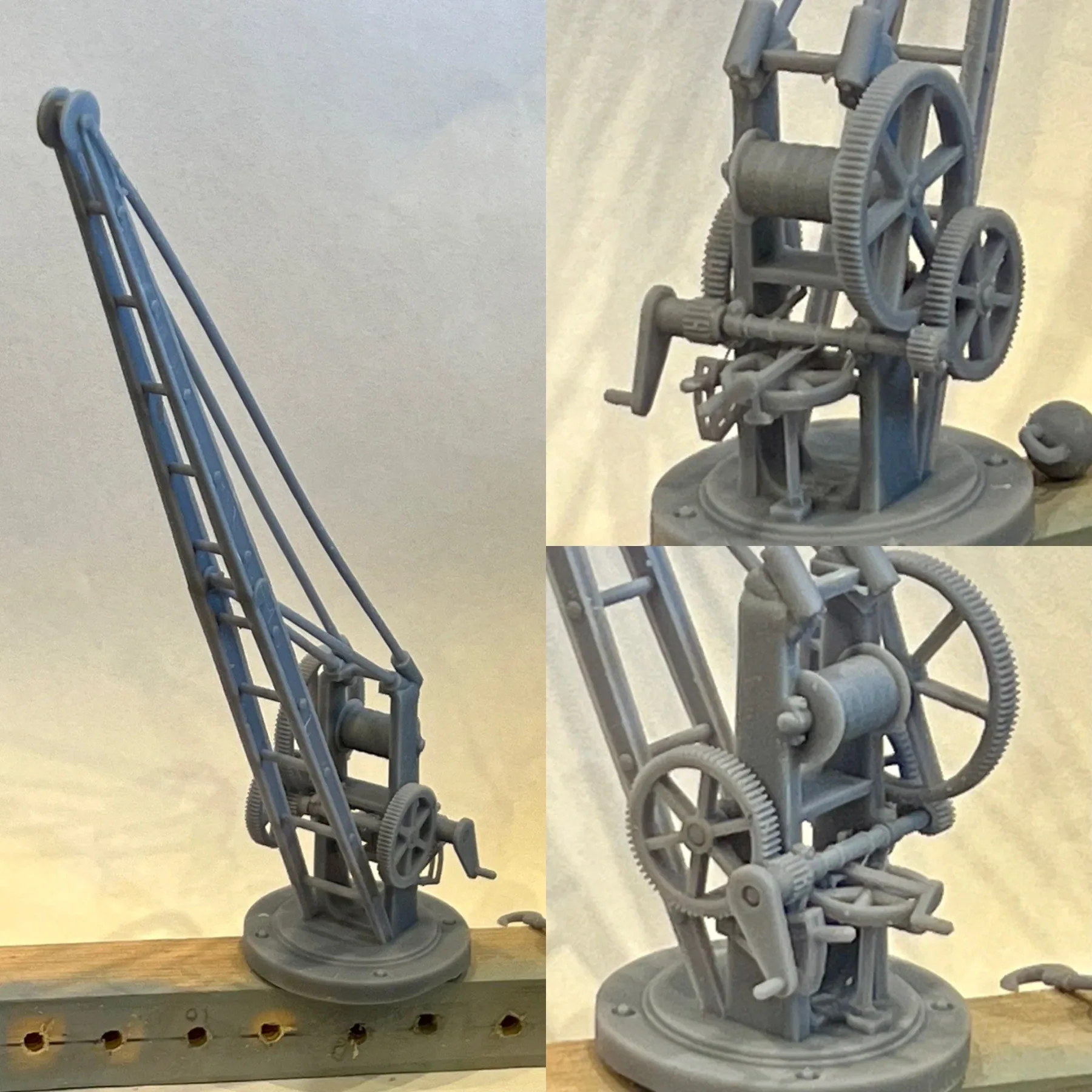 Grey model of a hand-operated crane with exposed gears