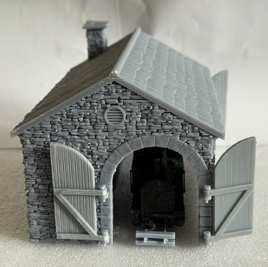 Gable end of the 009 loco shed with both strap-hinged doors open and a locomotive inside