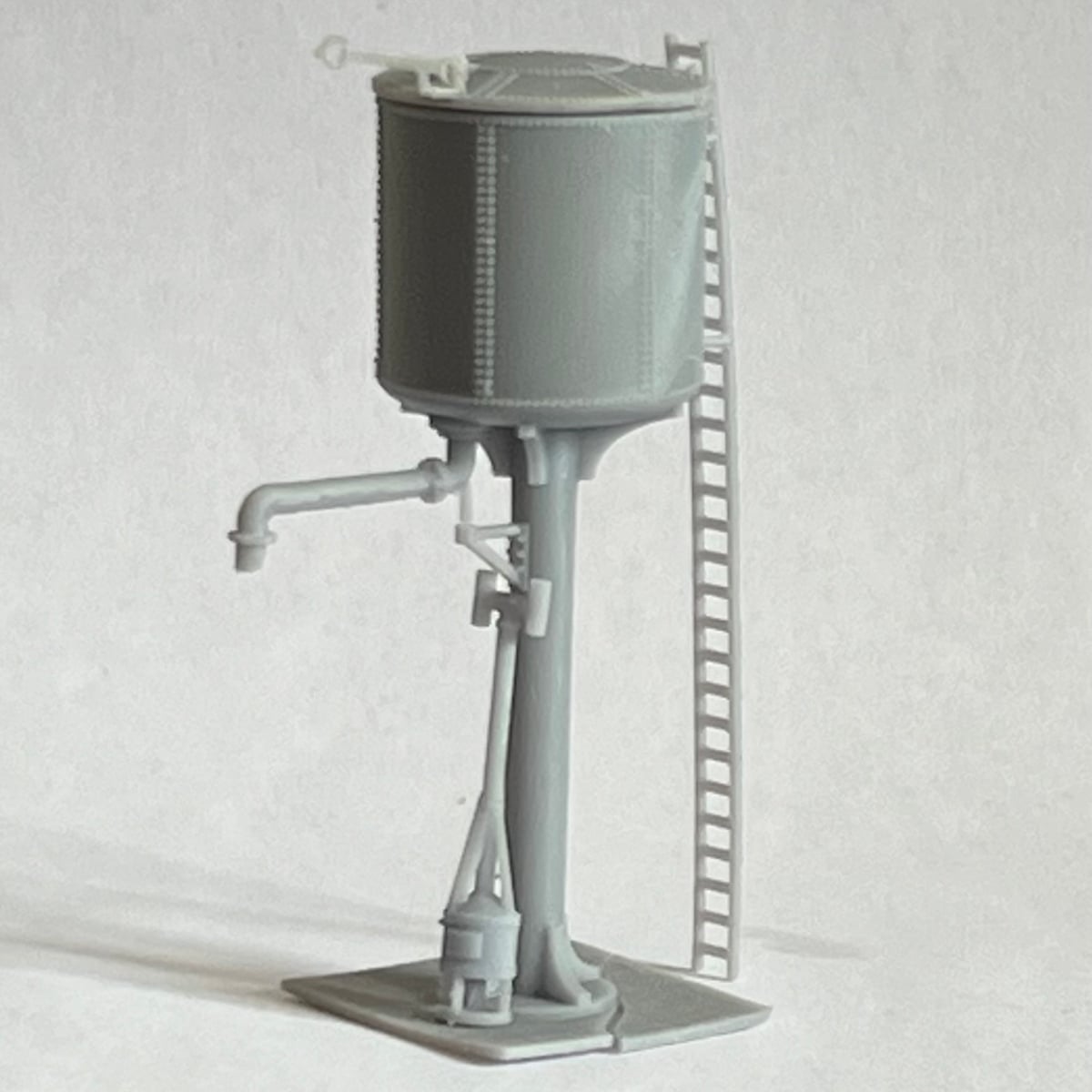 Unpainted print of the mainline water tower with its riveted tank, lid, filler arm and ladder, and the heater standing at the foot of the column.