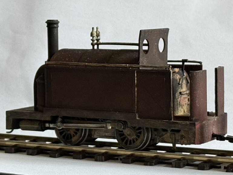 Weathered printed saddle tank locomotive in red-brown on O16.5 track, with tall chimney, open cab and spectacle plate.