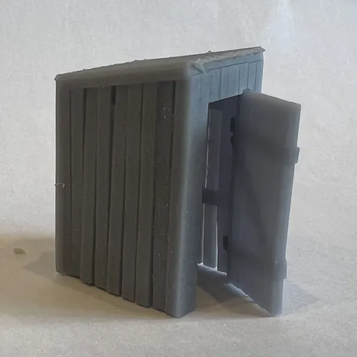 Printed plank-built privy with a sloping roof and its door standing open on strap hinges.