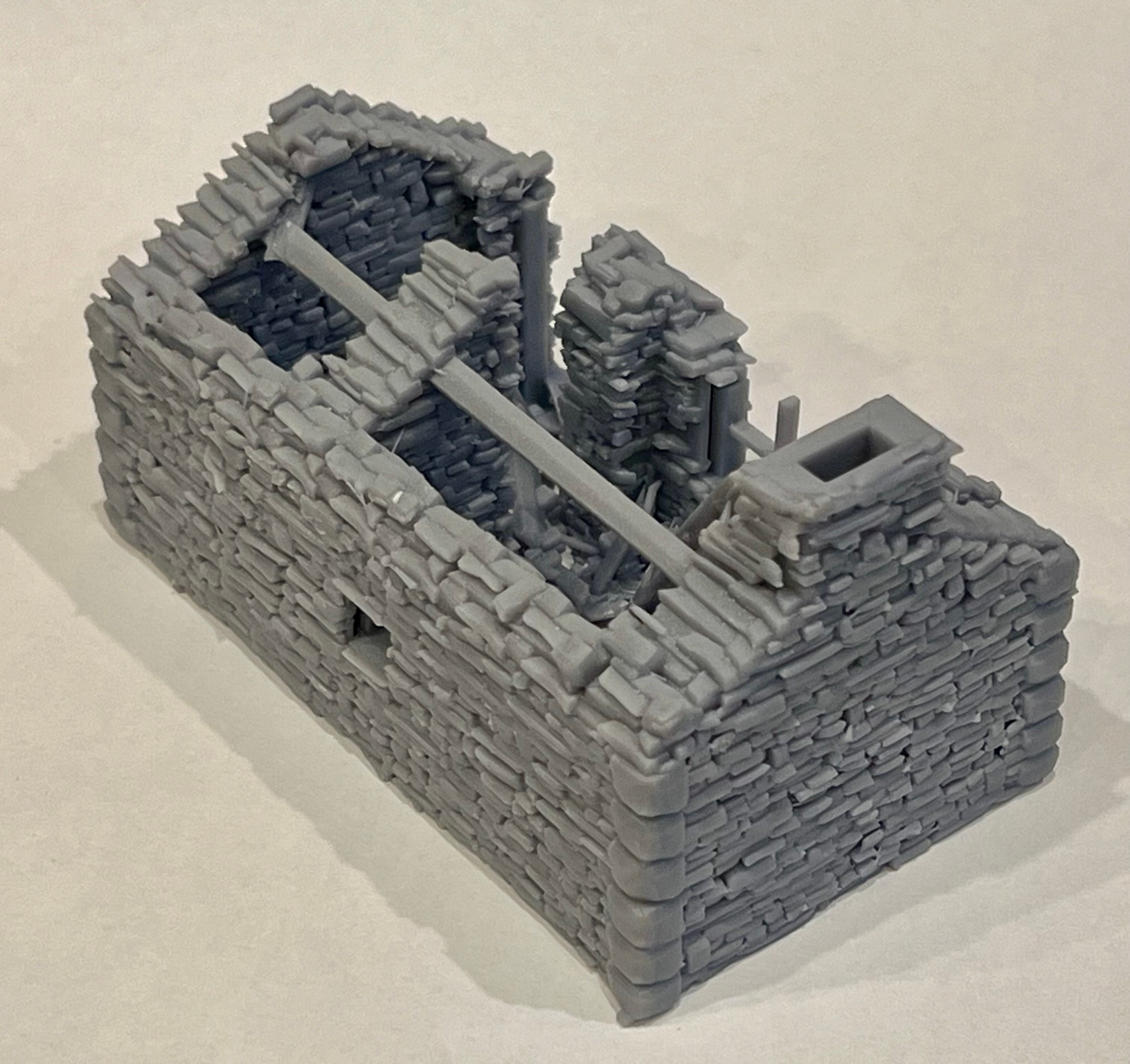 High angle view into the ruined cottage model showing hollow stone walls and broken roof structure