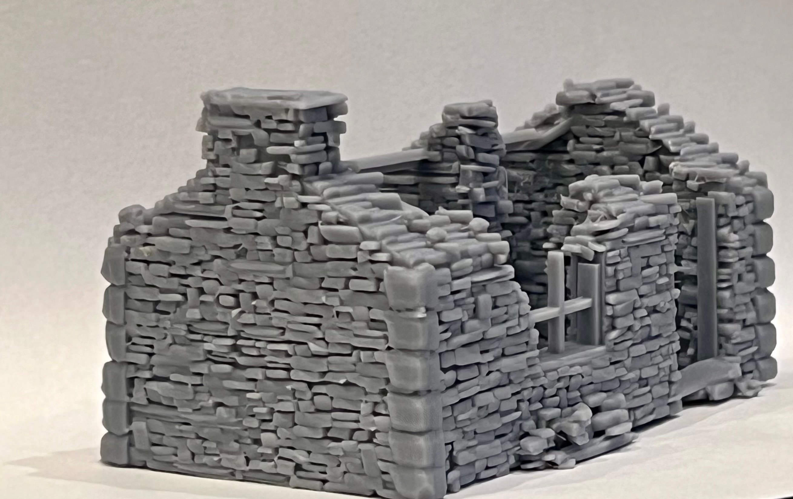 Low side view of the ruined cottage model showing the footprint, doorway, and stonework texture