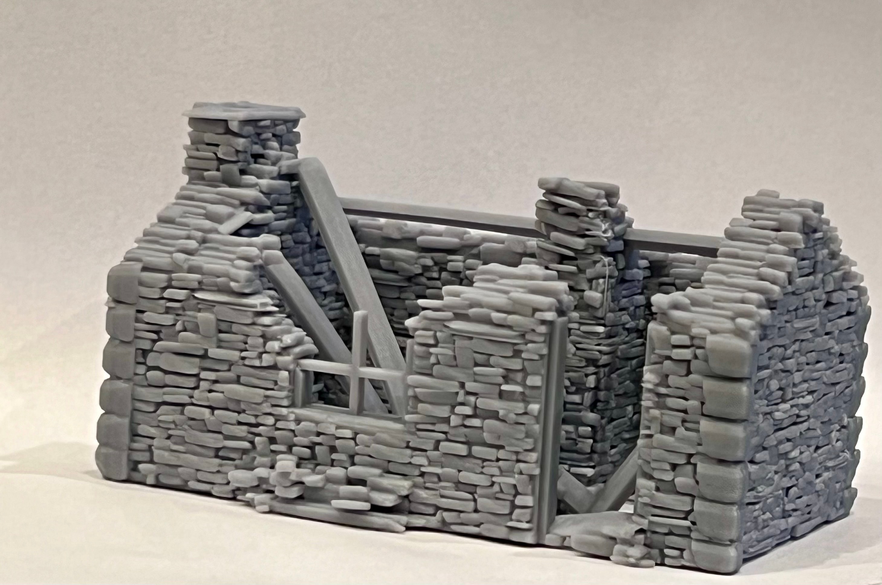 Angled exterior view of the ruined cottage model showing broken walls and collapsed roof beams