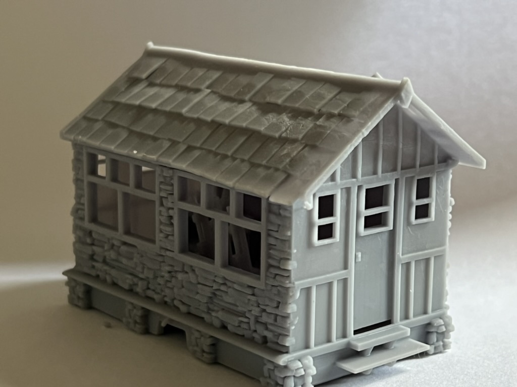 Unpainted printed signal box showing the stone base, multi-pane windows, slate roof and timber-clad entrance with steps