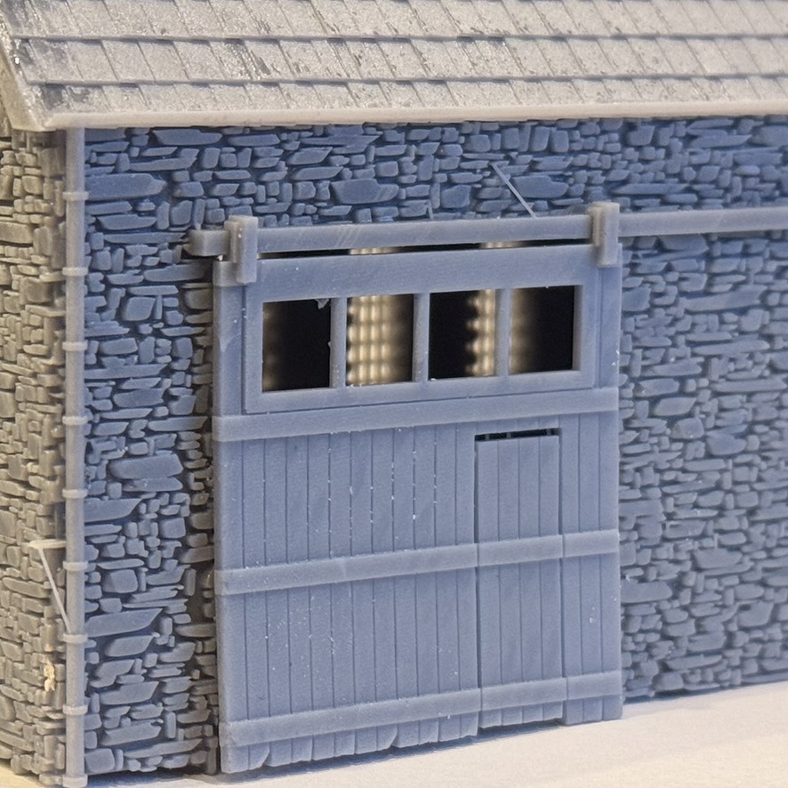 Close-up of the printed sliding door with its glazed top panel, plank boarding, wicket door and overhead rail.