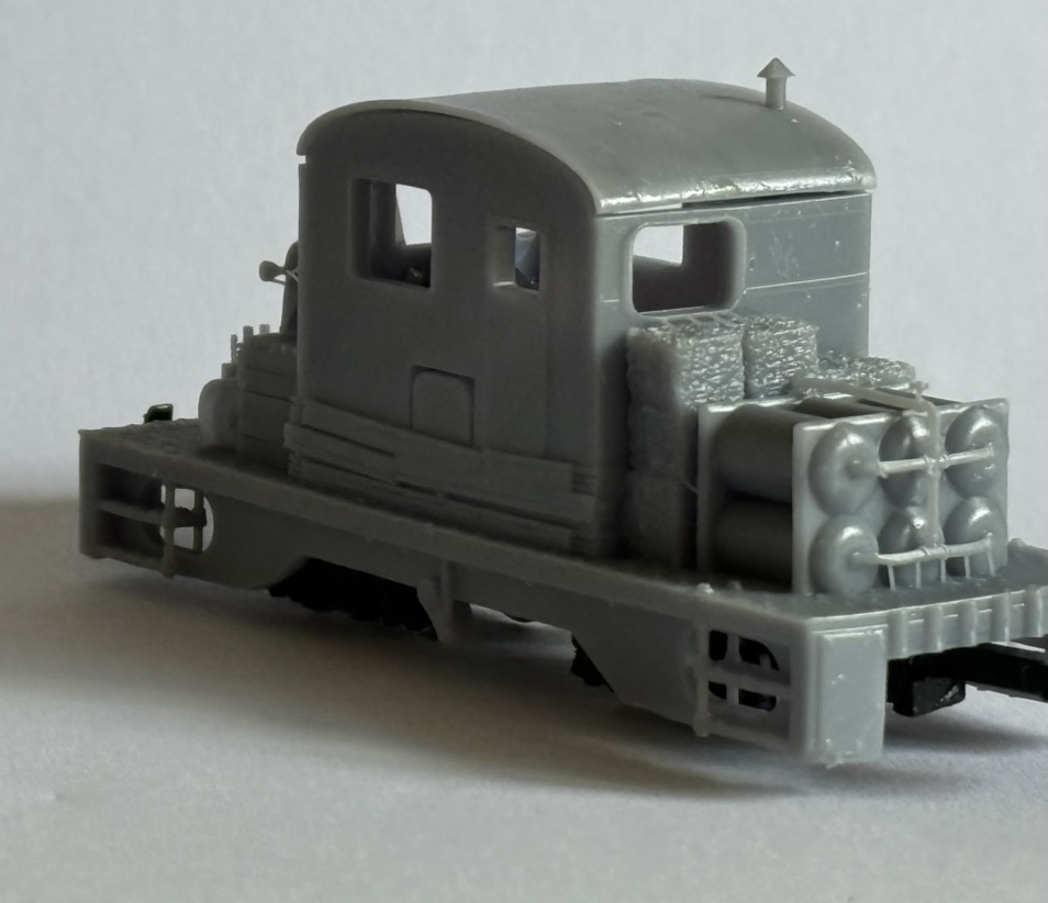 Rear three-quarter view of the printed tractor loco showing the curved cab roof, rear platform and stored equipment.