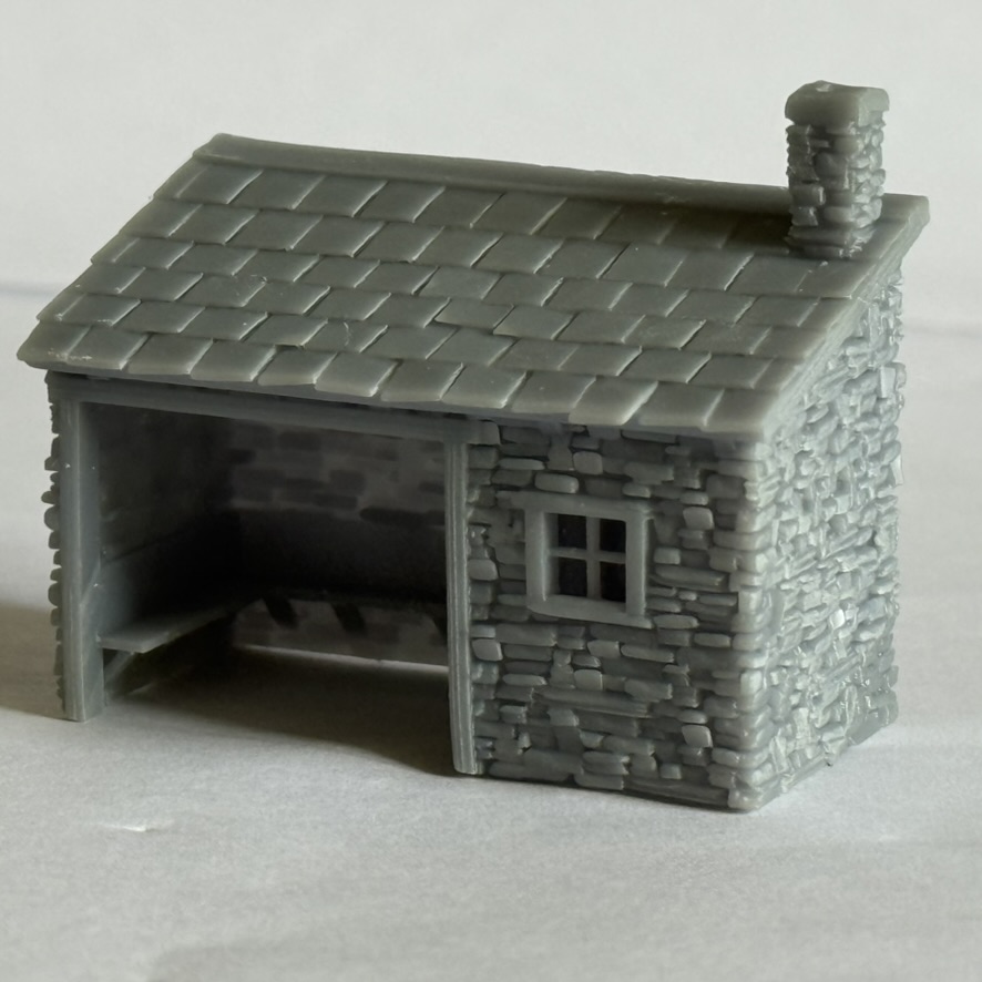Three-quarter view of the printed stone waiting room with slate roof, chimney, window and open shelter bay.