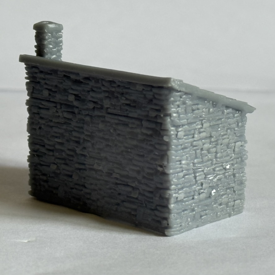 Rear and side view of the printed waiting room showing the stone wall texture and chimney.
