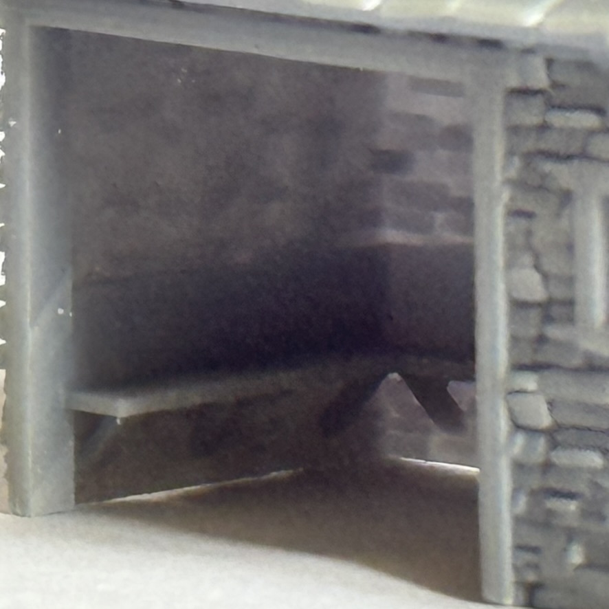 Close-up of the waiting room shelter interior showing the bench and stonework detail.