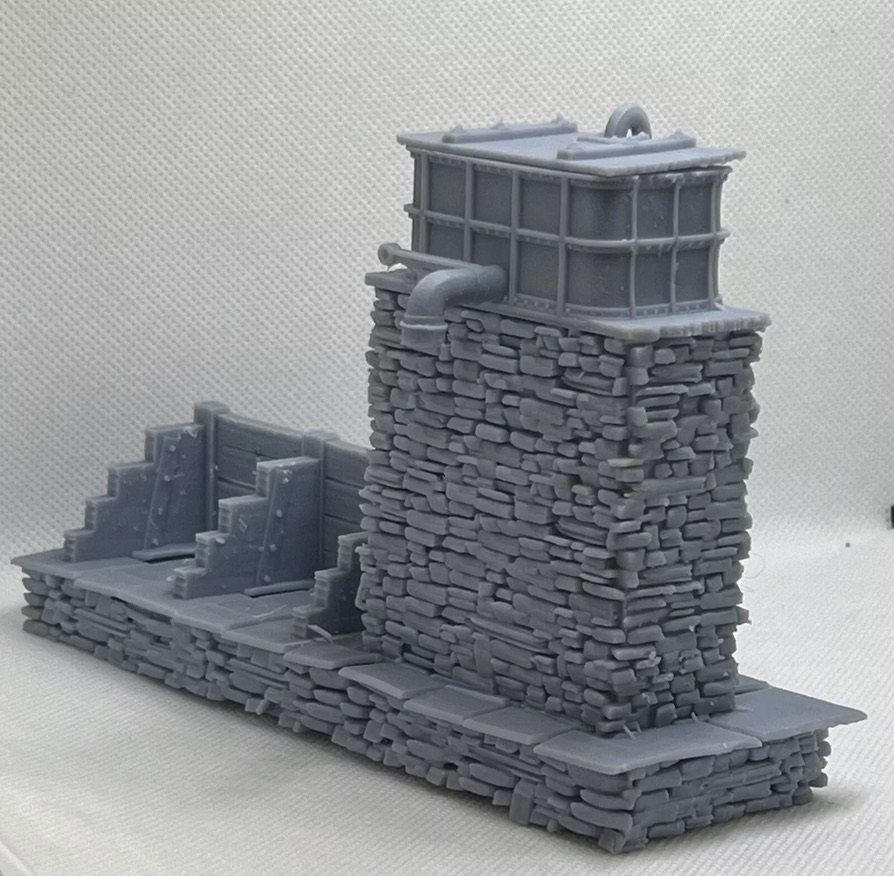 Tank-side three-quarter view of the printed water tower and coaling stage with stonework, pipe and coal bays.